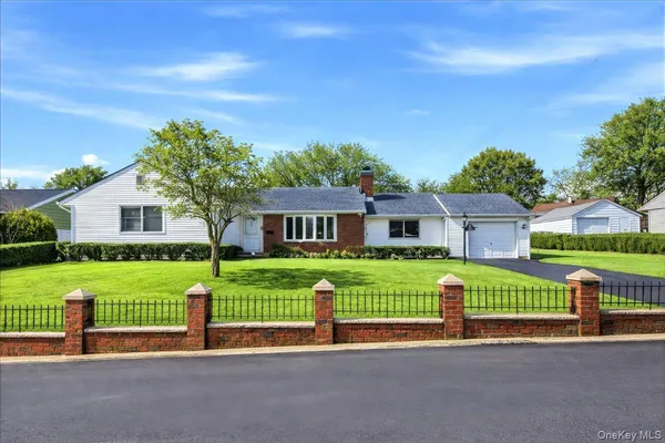 a front view of a house with a yard and fence