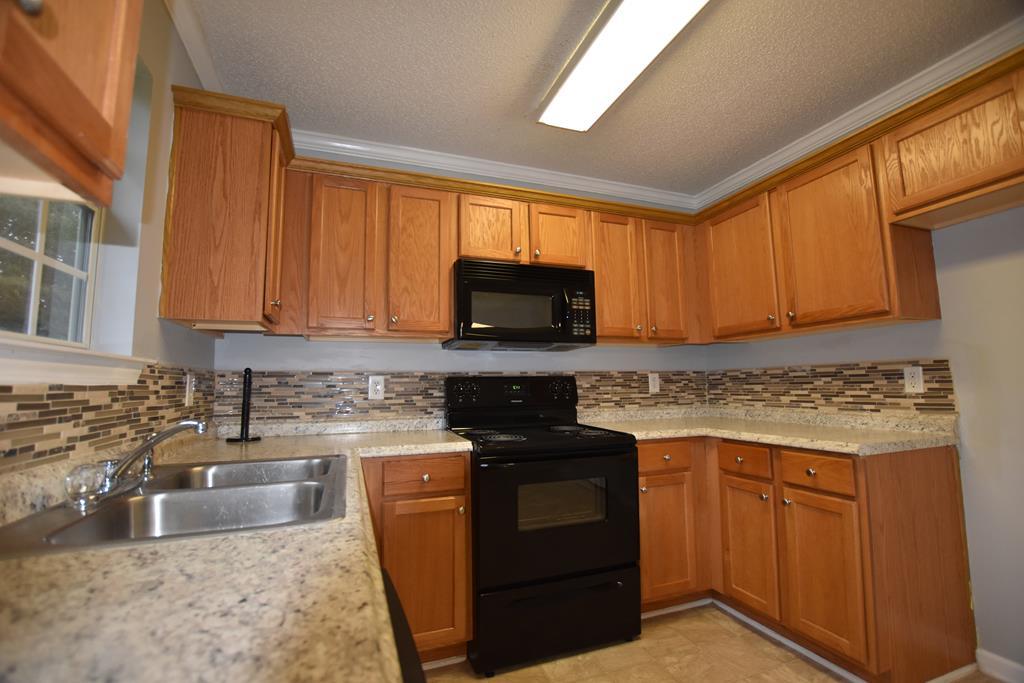 3315 Trotter''s Ridge Trail Gray, GA 31032 - Photo 6 of 26 a kitchen with granite countertop a sink stove and microwave