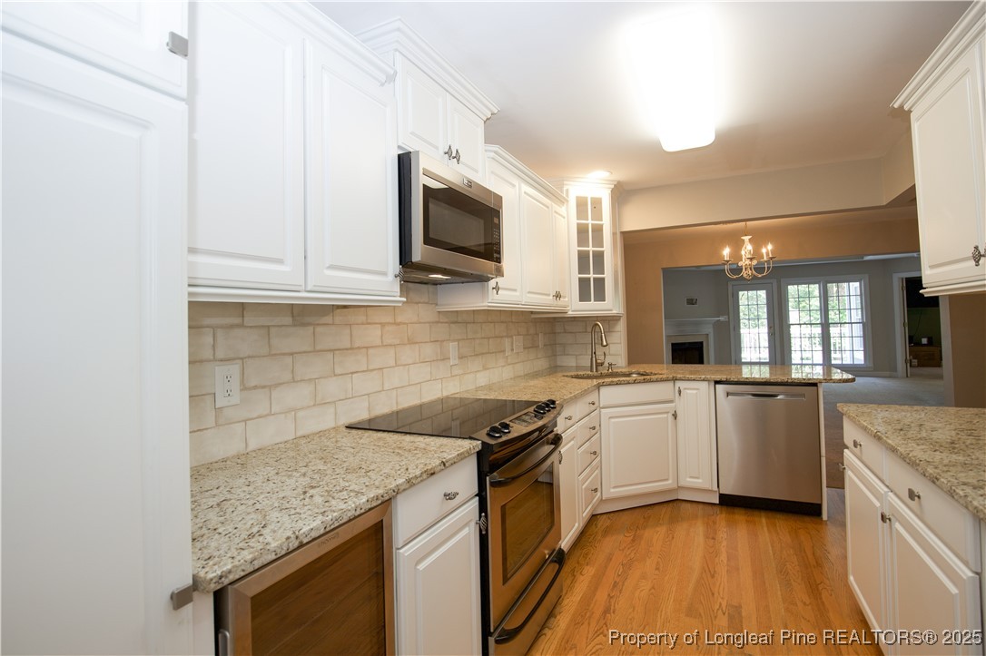 175 Knoll Road Southern Pines, NC 28387 - Photo 12 of 50 a kitchen with stainless steel appliances granite countertop a sink a stove top oven and white cabinets