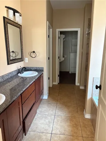 a bathroom with a granite countertop sink and mirror