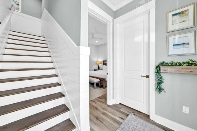 a view of a hallway with wooden floor and staircase