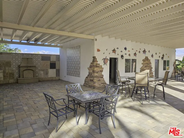 a patio with glass top table and chairs