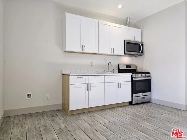 a view of a kitchen with wooden floor and a sink
