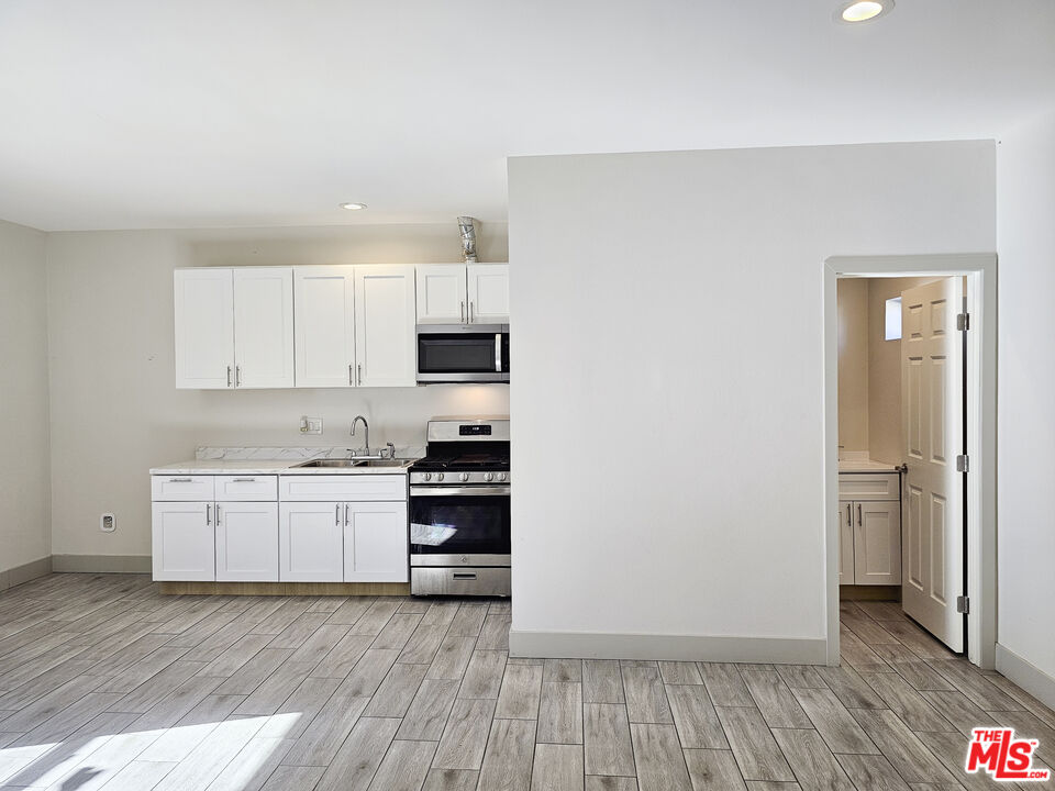 38580 Rancho Los Cerritos Drive, Unit S2 Indio, CA 92203 - Photo 9 of 44 a kitchen with wooden floors and white appliances