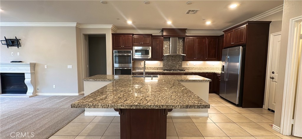 33833 Edge Temecula, CA 92592 - Photo 10 of 18 a kitchen with kitchen island granite countertop a refrigerator and a sink