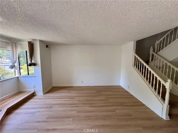 a view of an empty room with window and stairs