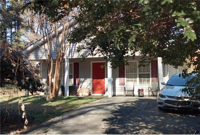 a front view of a house with a yard and tree s