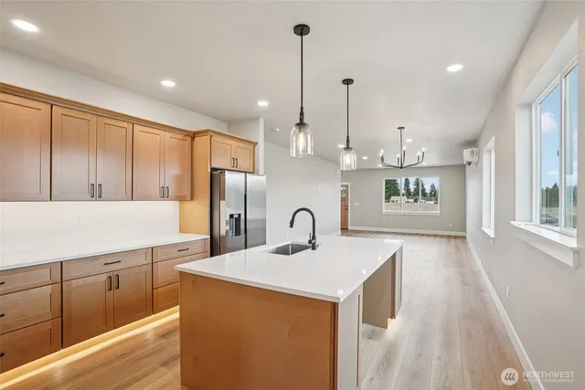 a kitchen with kitchen island granite countertop a sink a counter top space stainless steel appliances and cabinets