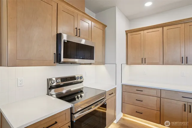 a kitchen with a microwave and a stove top oven