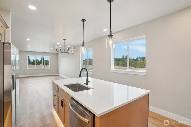 a kitchen with stainless steel appliances a sink a stove a refrigerator and cabinets
