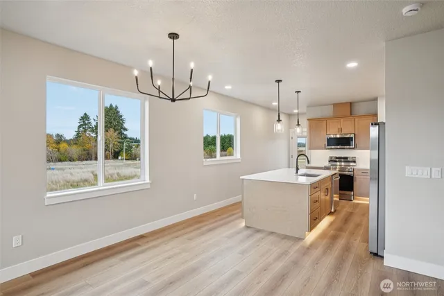 a view of a kitchen with microwave and wooden floor