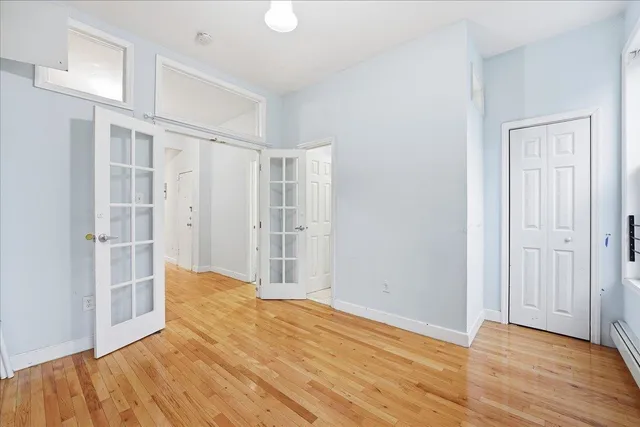 a view of empty room with wooden floor and entryway
