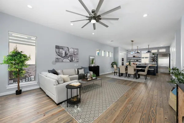 a living room with furniture and a large window with wooden floor