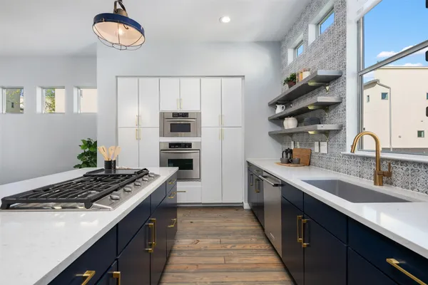 a kitchen with stainless steel appliances a sink stove and cabinets