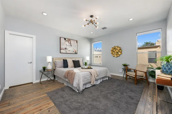 a spacious bedroom with a bed and a chandelier
