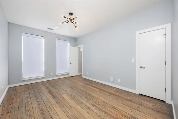 a view of an empty room with wooden floor