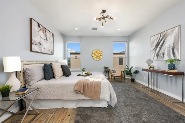 a bedroom with a large bed and a chandelier