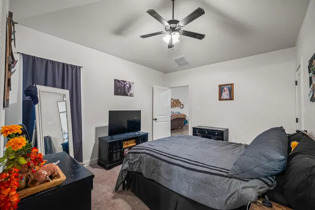 a bedroom with a bed window and a flat screen tv