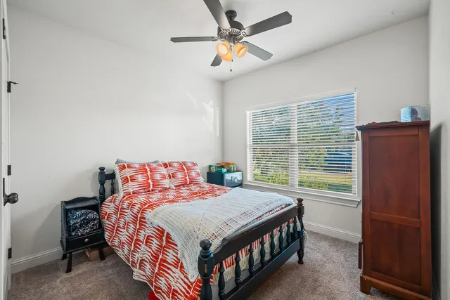 a bedroom with a bed a window and a chandelier