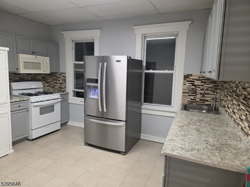 846 Market Street Paterson, NJ 07513 - Photo 2 of 11 a kitchen with a refrigerator sink and cabinets
