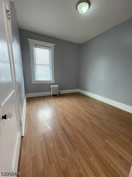 846 Market Street Paterson, NJ 07513 - Photo 5 of 11 an empty room with wooden floor and windows