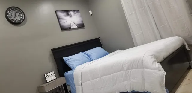 a bedroom with a bed and painting on the wall