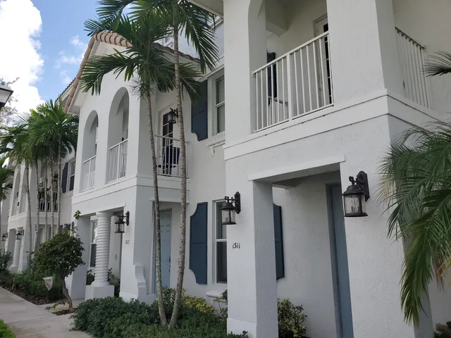 a view of a house with a palm tree beside it