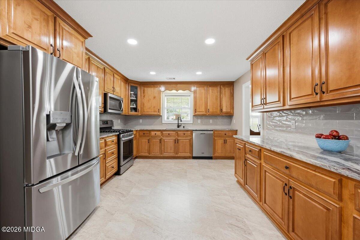 557 Aarons Circle Gray, GA 31032 - Photo 11 of 36 a kitchen with stainless steel appliances granite countertop a refrigerator sink and cabinets