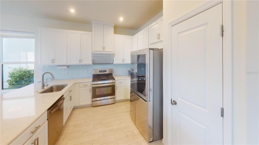 5521 Summit Glen Bradenton, FL 34203 - Photo 42 of 54 a kitchen with stainless steel appliances white cabinets and a refrigerator