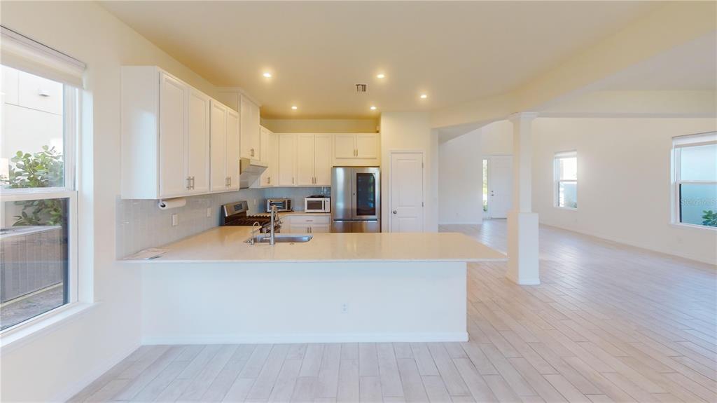 5521 Summit Glen Bradenton, FL 34203 - Photo 43 of 54 a view of kitchen with kitchen island a sink wooden floor and white stainless steel appliances