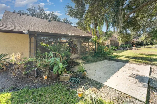a view of a backyard house with large trees and plants
