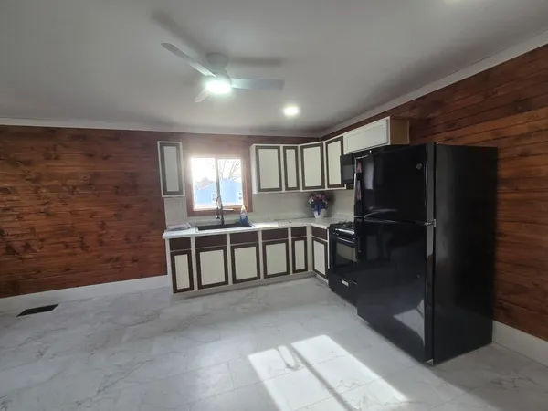 a large kitchen with a refrigerator a sink and dishwasher