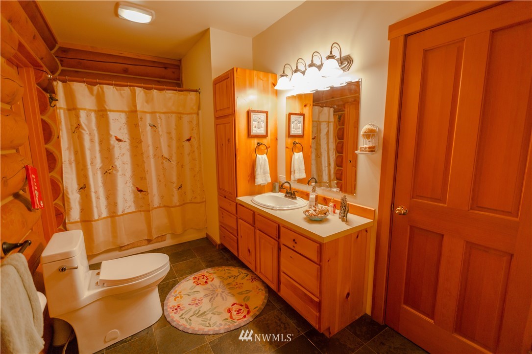 12057 Havekost Road Anacortes, WA 98221 - Photo 28 of 40 a bathroom with a sink a toilet and shower curtain