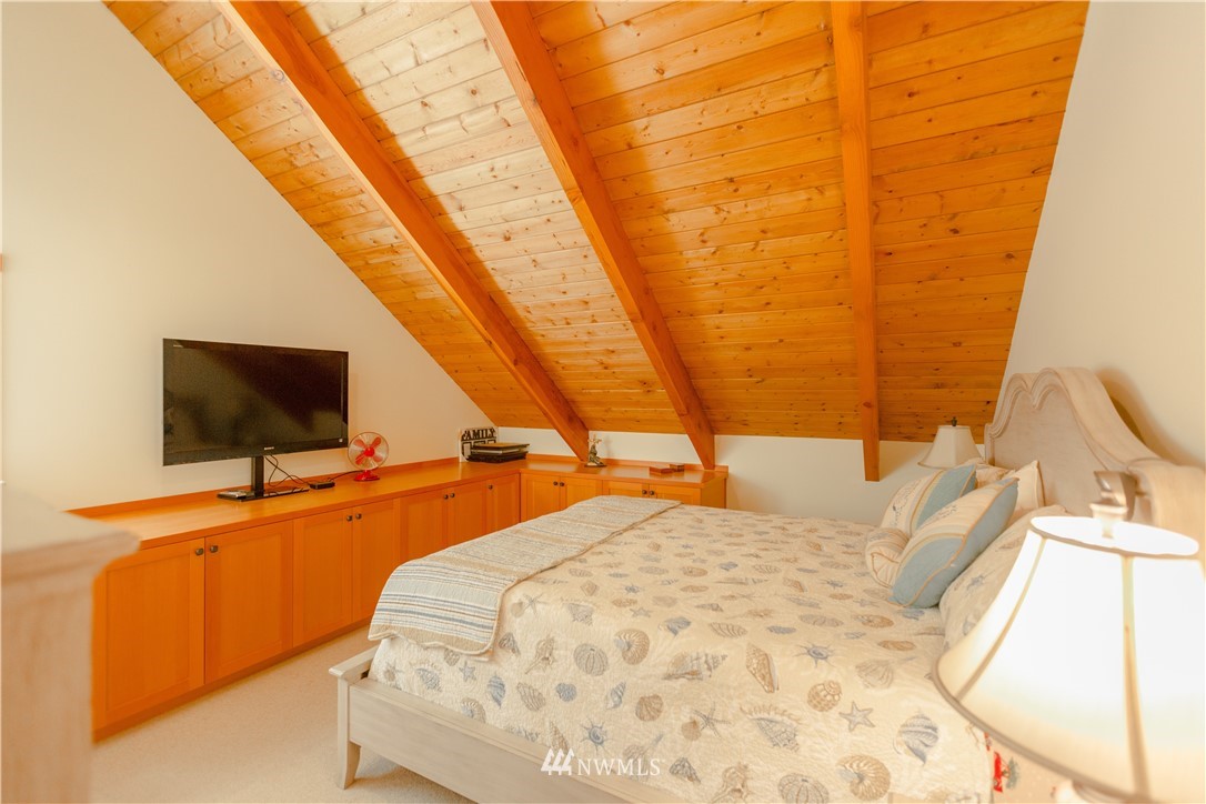 12057 Havekost Road Anacortes, WA 98221 - Photo 33 of 40 a bedroom with a bed and a flat screen tv