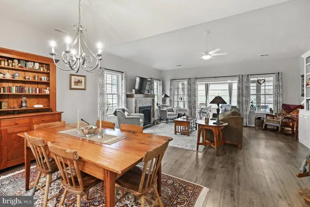 a view of a dining room with furniture a chandelier and wooden floor