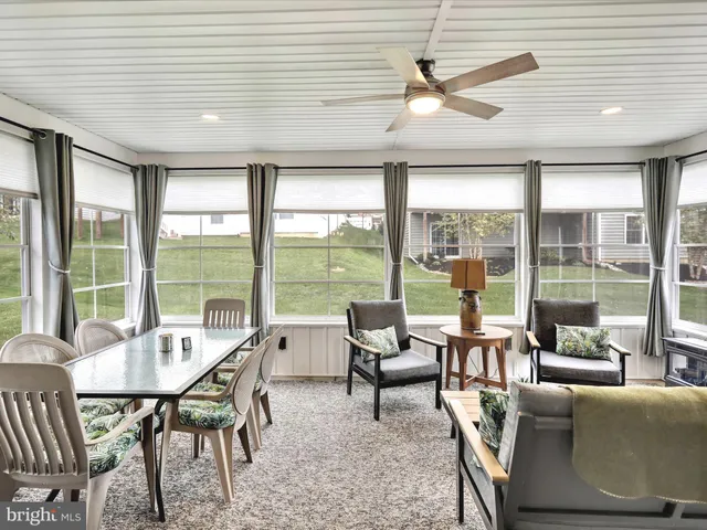 a view of a dining room with furniture large windows and wooden floor