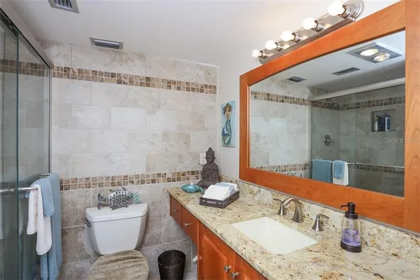 a bathroom with a granite countertop sink and a mirror