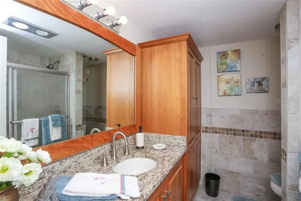 a bathroom with a granite countertop sink and a mirror