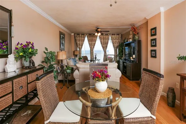a living room with furniture a large window and wooden floor