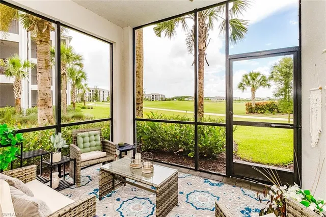 a living room with large windows and a table