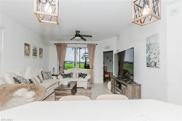 a living room with furniture a chandelier and a flat screen tv