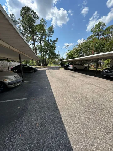 a view of street with small yard and large trees