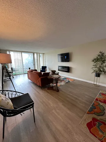 a living room with furniture a flat screen tv and gym equipment