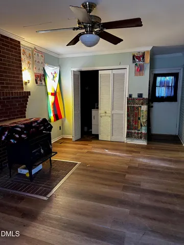 a room with wooden floor and ceiling fan