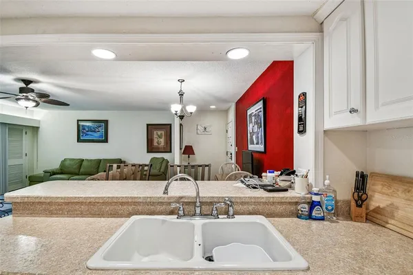 a kitchen with granite countertop a sink stove and refrigerator