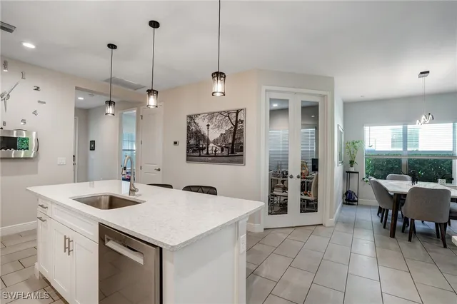 a kitchen with a sink a counter and chairs