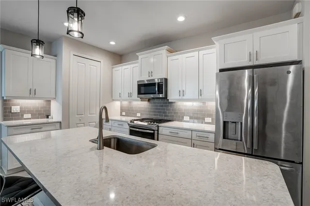 a kitchen with kitchen island a counter top space appliances and cabinets