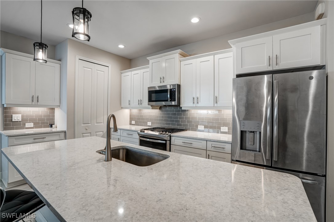 7028 Mistral Way Fort Myers, FL 33966 - Photo 12 of 37 a kitchen with kitchen island a counter top space appliances and cabinets