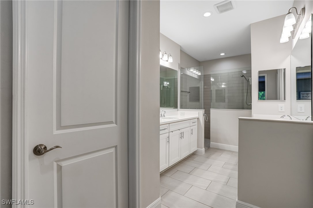 7028 Mistral Way Fort Myers, FL 33966 - Photo 17 of 37 a large bathroom with a double vanity sink and mirror