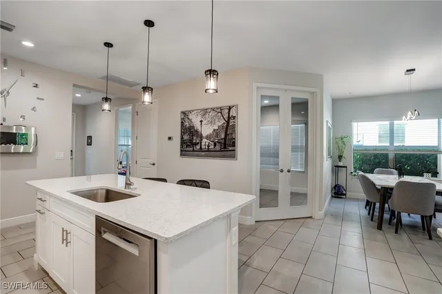 a kitchen with a sink a counter space and a chandelier